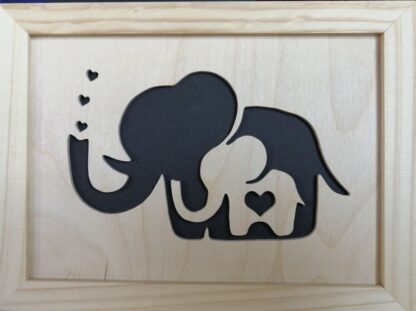 Cadre « éléphanteau dans éléphant » fond noir, encadrement bois naturel.